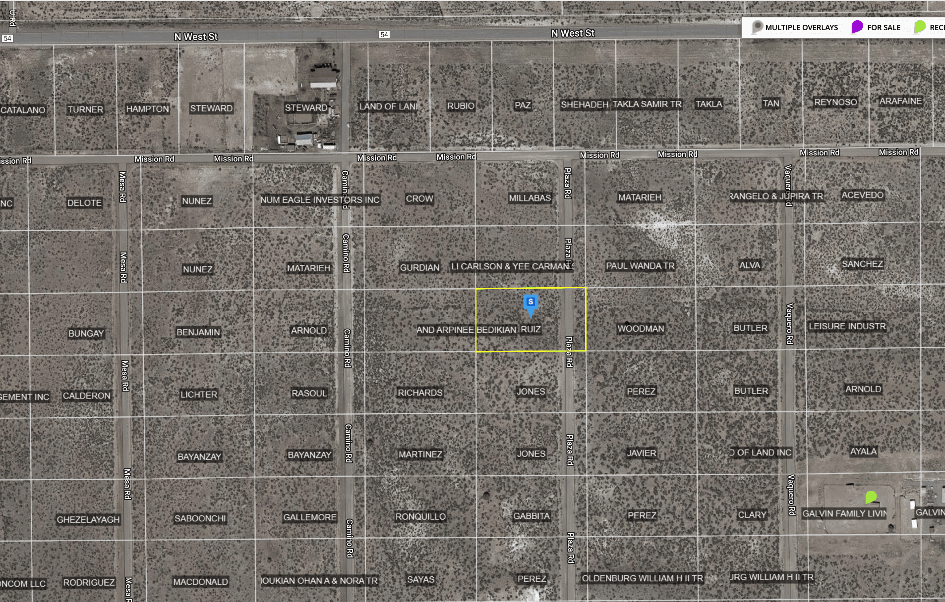 Aerial view of a plotted land map showing streets and labeled property boundaries in a desert area.